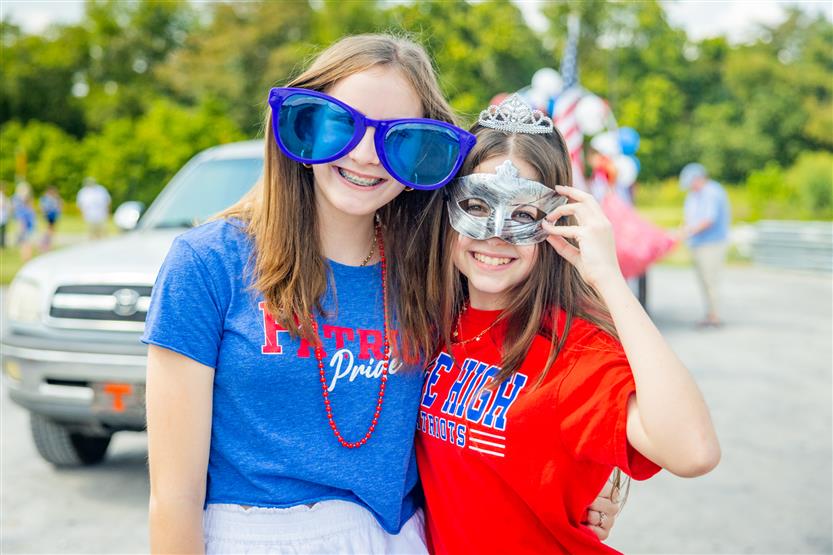 Two girls smile at the Page High homecoming parade